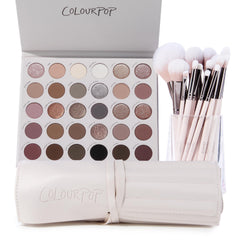 The Ultimate Stunner ColourPop Shadow Palette & Brush Set displaying an open 30‑pan neutral matte and shimmer eyeshadow palette beside pink‑handled makeup brushes in a clear cup and a cream brush roll, on a white background.