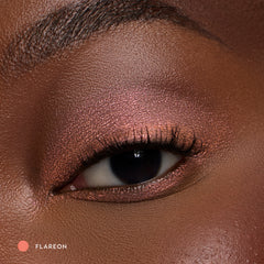 Close-up of a deep-skin eye wearing Flareon tangerine shadow stick
