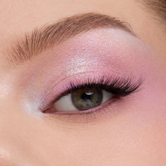 Shimmering pastel pinkβlilac eyeshadow blends across a close-up eyelid with fluttery lashes, showcasing the color payoff of the In A Trance shadow palette, a ColourPop Shadow Palette, perfect for soft, iridescent looks.