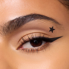 Close-up of a medium-skin eye with a sharp black winged liner and a black star stamp
