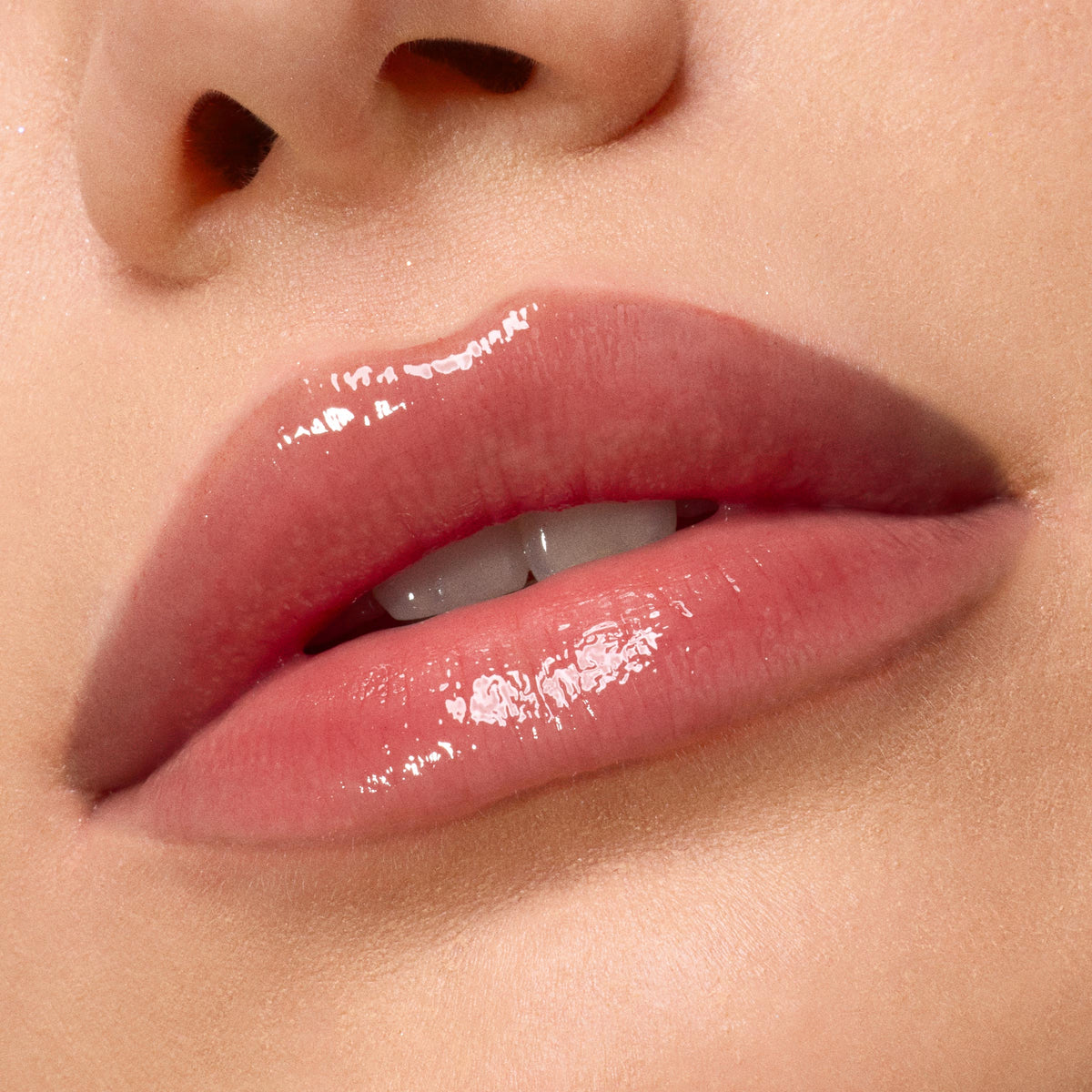 Glossy, hydrated lips showcase Kiss of Darkness from the ColourPop Lip Care Kit, delivering a high-shine, soft pink finish in a macro close-up against smooth, natural skin.
