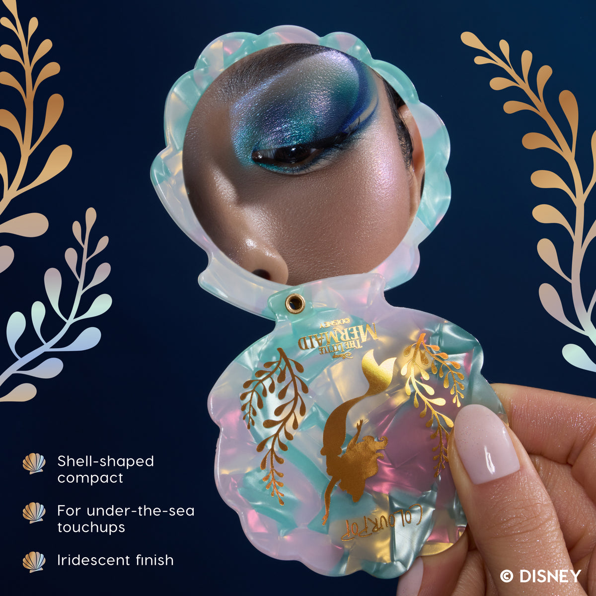 Hand holding the iridescent shell-shaped Little Mermaid compact mirror open