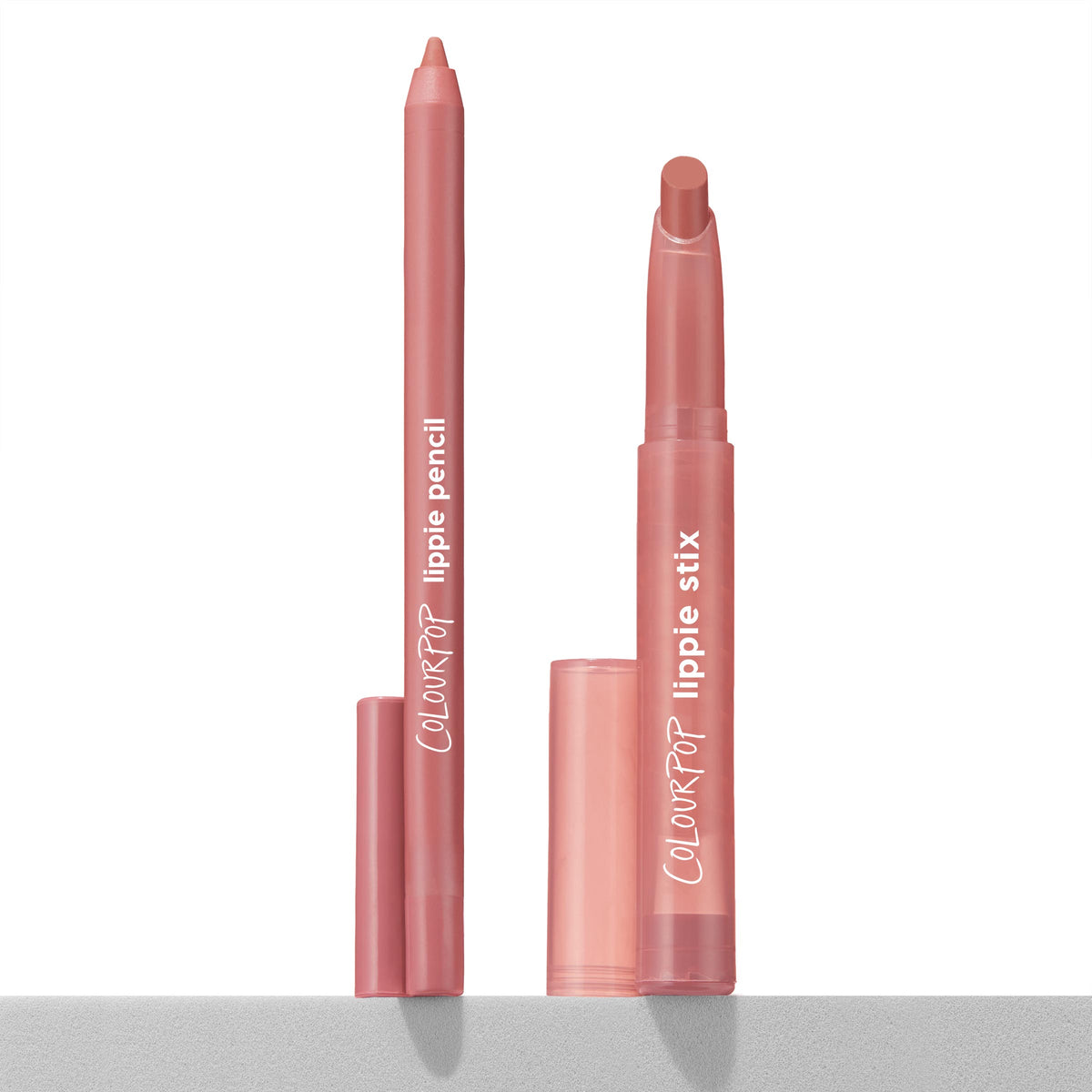 Double the Trouble ColourPop Lippie Stix + Pencil Set stands uncapped on a white surface - rosy mauve lip pencil and matching twist-up lippie stix in pink tubes with COLOURPOP logo, caps below - designed for precise lining and full-lip fill.