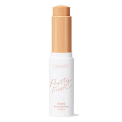 ColourPop Pretty Fresh Tinted Foundation Balm, shade Medium 11, shown twisted up in a white stick with peach lettering, cap off to reveal a warm medium-beige balm, standing upright against a clean white background.