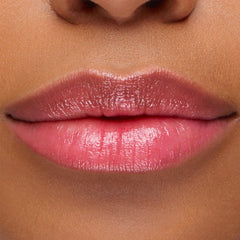 Glossy lips wearing Sing, a ColourPop pH Lip Balm, reveal a soft rosy pink tint that adapts to skin pH, with smooth, hydrated shine in a close-up lip swatch.