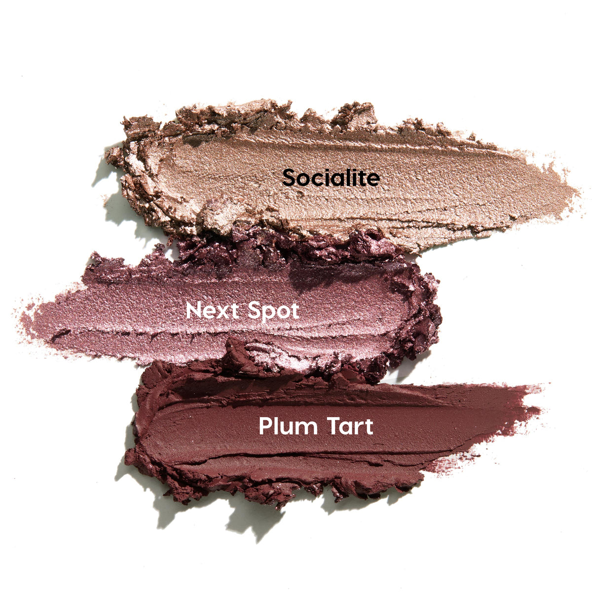 Three ColourPop Shadow Stix swatches from the Rose Goals set - Socialite, Next Spot, and Plum Tart - spread in thick strokes on a white background, showing creamy texture with champagne shimmer, metallic mauve, and deep matte plum.