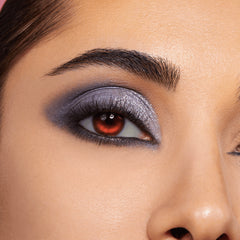 Smoky silver-lavender shimmer eyeshadow with charcoal blend and glitter accents covers a modelβs lid, paired with bold lashes and a red contact lens, showcasing the Twilight Shadow Palette, a ColourPop Shadow Palette.