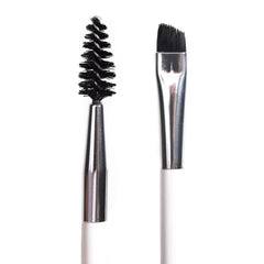 ColourPop Brow Dual Ended Brush makeup brush shaping and defining eyebrows, featuring a black spoolie on one end and an angled flat brush on the other with silver ferrules and a white handle, shown in a studio close-up on a white background.