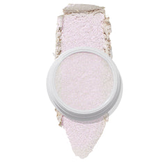 ColourPop Spellbound Super Shock Highlighter in a white pot, displaying an iridescent pink-lilac glow, with a broad swatch stroke beneath the pan showing its soft, shimmery payoff on a clean white background.