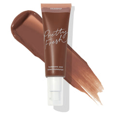 ColourPop Pretty Fresh Tinted Moisturizer tube in Deep Dark 22 N (neutral deep) with hyaluronic acid sits over a cocoa-brown swatch on white, highlighting the shade and pump-top packaging for lightweight, hydrating coverage.