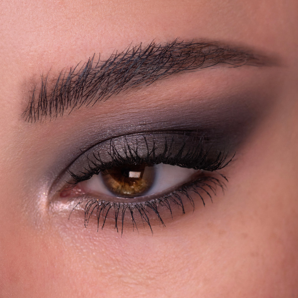 Smoky eye wearing cool taupe-to-charcoal shimmer and matte shades from the ColourPop Of Quartz shadow palette, lashes defined and brow groomed, close-up beauty shot showing seamless blend and inner-corner highlight.