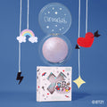 Captivating Villain Crystal Glow Bouncy Highlighter, a lavender domed pan, with its BT21 box on a blue backdrop