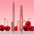 ColourPop Perfect Duo Lippie Stix + Pencil Set standing upright, revealing rosy nude tips with clear caps, framed by glossy red cherries on a pink gradient backdrop, ideal for precise lining and creamy lip color.