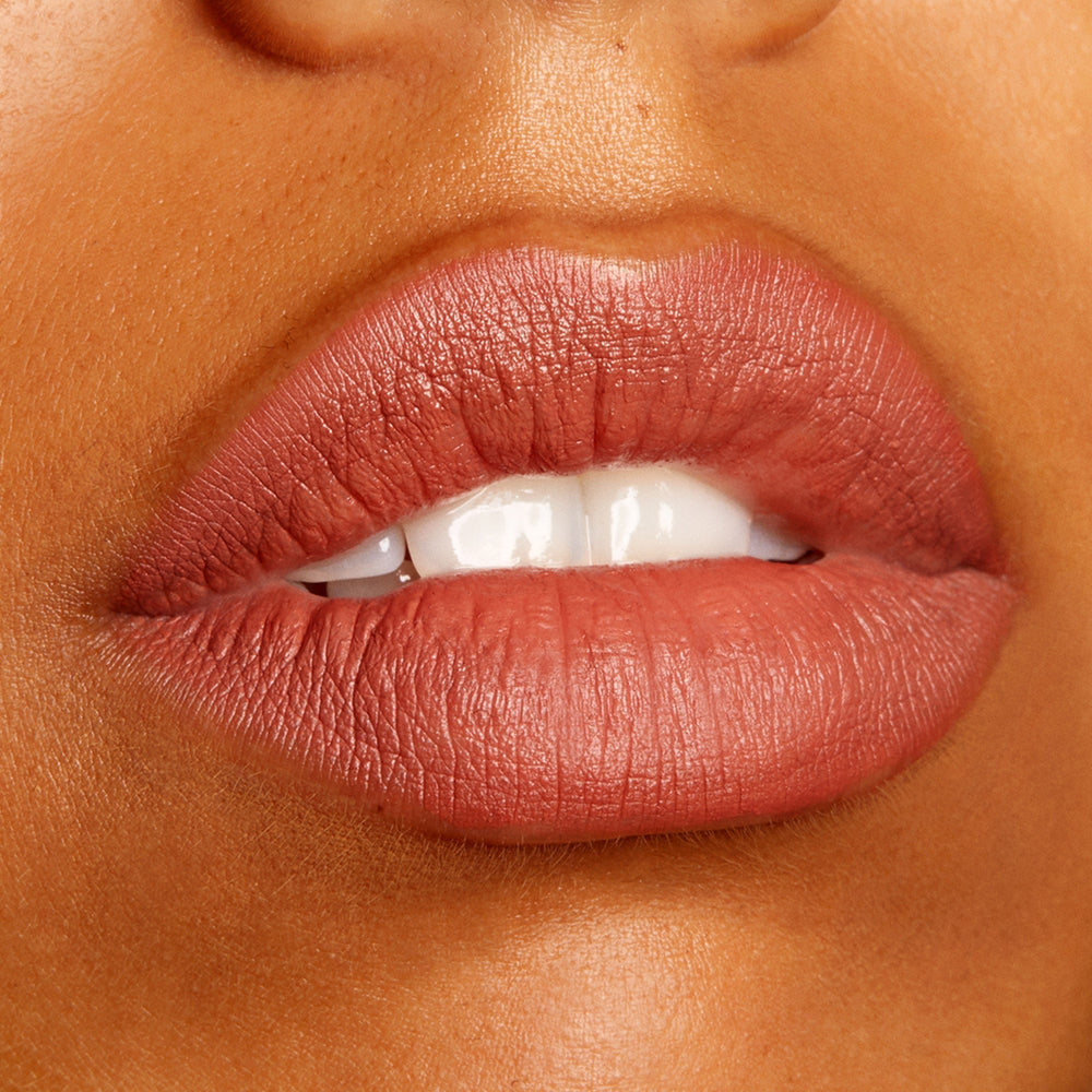 Lips wear Brink, a ColourPop Lippie Pencil, defining and filling the mouth in a warm rosy terracotta nude with a soft matte finish, shown in a close-up beauty swatch to highlight the creamy, long-wearing precision of this lip liner.