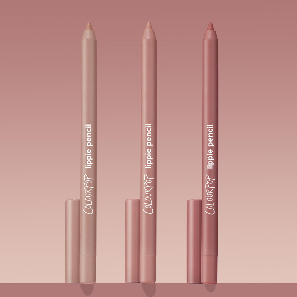 Trio of ColourPop Lippie Pencil Cool Besties standing upright, tips exposed, in light nude, pink nude, and rosy mauve tones with matching caps, arranged on a blush gradient background for a clean product shot.
