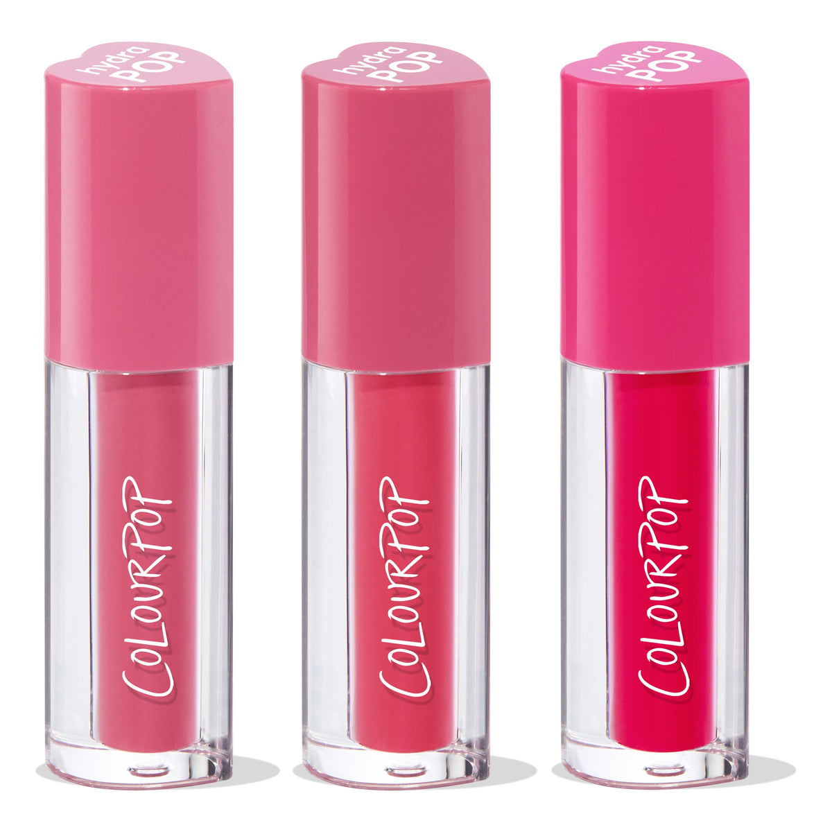 ColourPop Lip Stain Tickle Me Pink trio standing upright, each clear tube with white ColourPop logo and heart-shaped pink caps, showcasing soft rose, medium pink, and bold fuchsia shades on a white studio background.