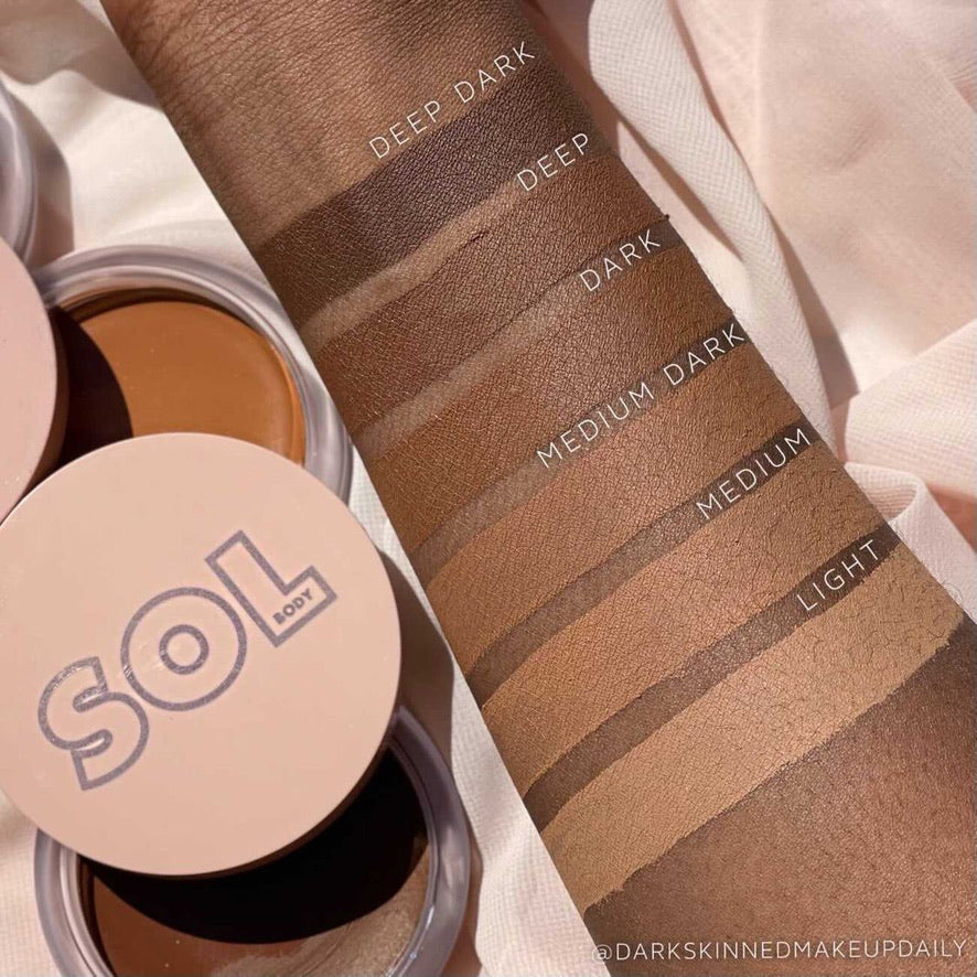 ColourPop SOL Face & Body Bronzing Balm in Medium Dark swatched on a forearm, with labeled stripes ranging Light to Deep Dark; open SOL compacts on soft fabric backdrop highlight the creamy, blendable bronzer for face and body.