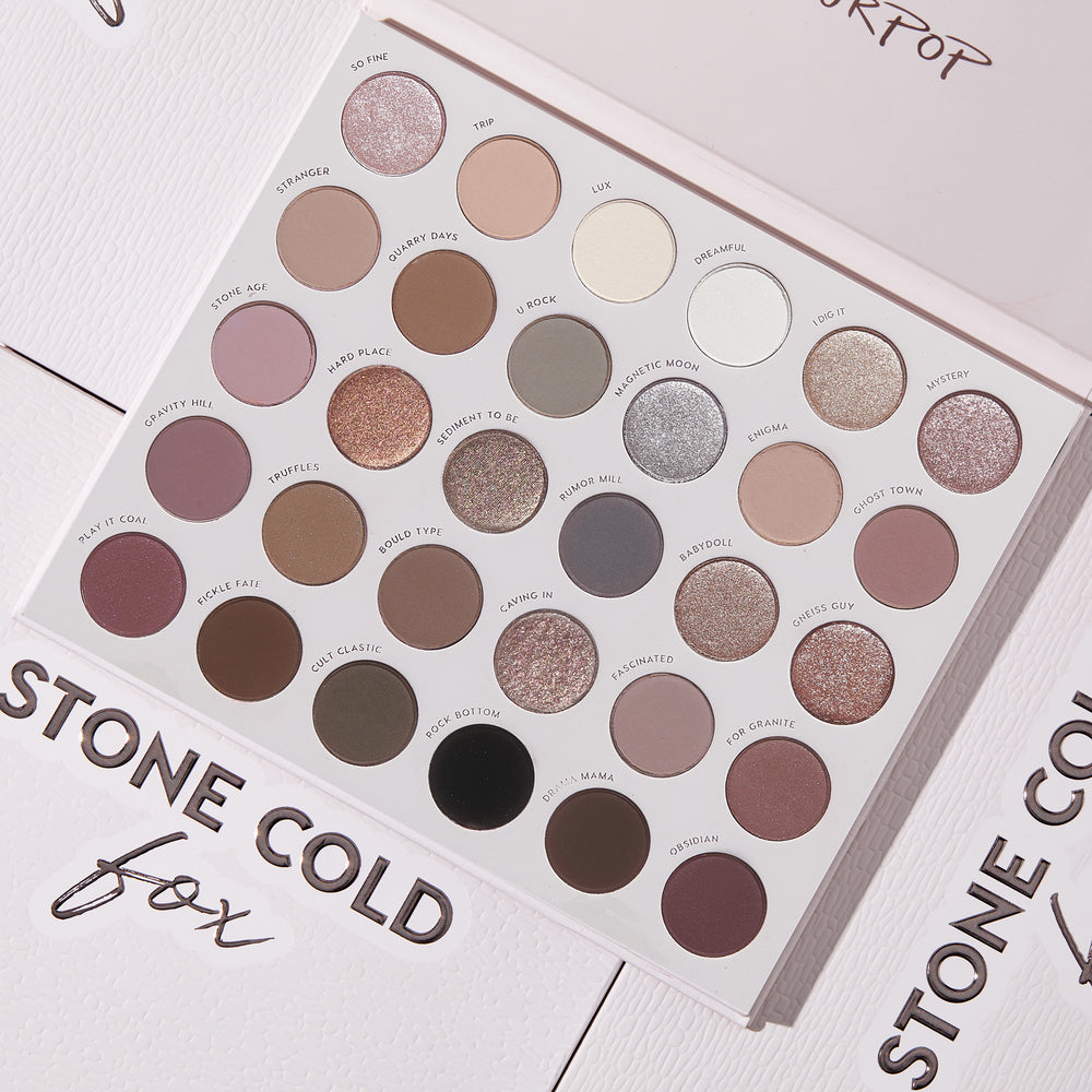Stone Cold Fox ColourPop Shadow Palette lying open, displaying a 30-pan range of cool-toned neutrals - taupes, mauves, grays, plums, and silvers - in matte, shimmer, and metallic finishes, each shade labeled on embossed white Stone Cold Fox packaging.