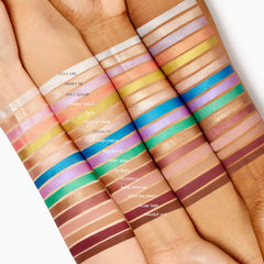 ColourPop Shadow Stix Rain Check swatched as a vivid cobalt-blue metallic stripe across three arms in varied skin tones, highlighting the creamy, one-swipe payoff of this twist-up eyeshadow stick amid assorted shade swatches.