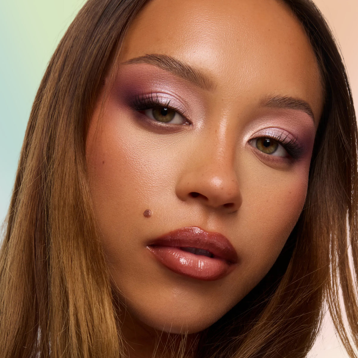 Model with medium-deep skin wearing a soft violet and pink smoky eye from the Eeveelution Eyeshadow Palette