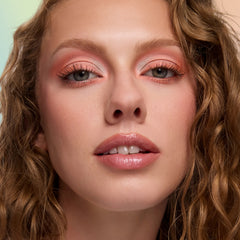 Model with fair skin wearing warm peach shadow from the Eeveelution Eyeshadow Palette