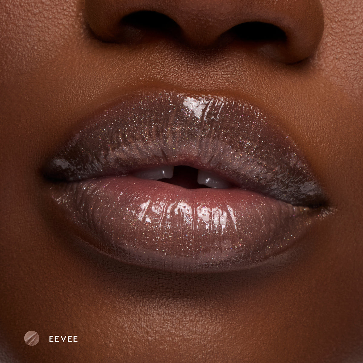 Close-up of deep-tone lips wearing Eevee sheer nude glossy lip balm with sparkle