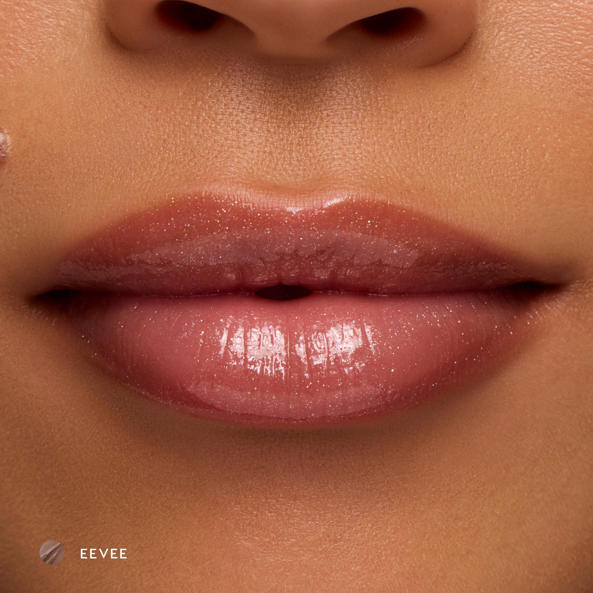 Close-up of medium-tone lips wearing Eevee sheer nude glossy lip balm