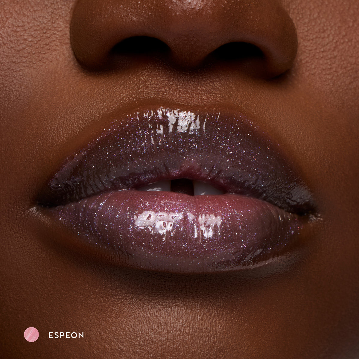 Close-up of deep-tone lips wearing Espeon sheer lilac glossy lip balm with sparkle