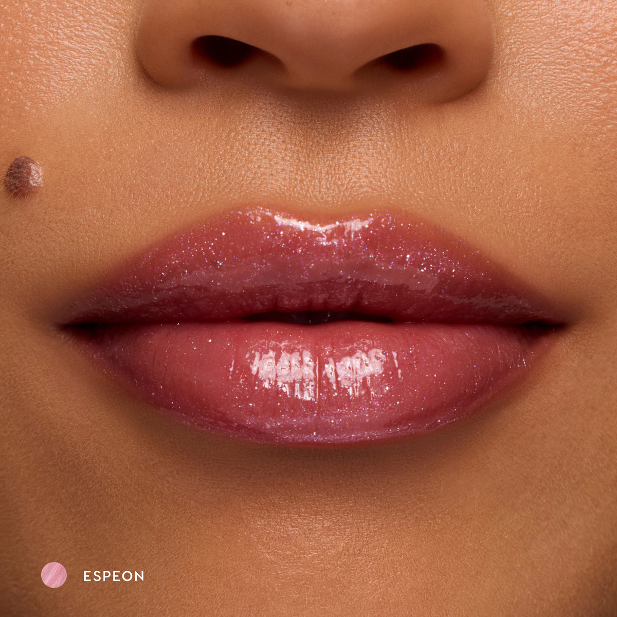Close-up of medium-tone lips wearing Espeon sheer lilac glossy lip balm