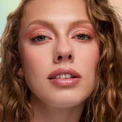 Model with fair skin wearing Espeon sheer lilac glossy lip balm with peach eyeshadow