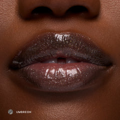 Close-up of deep-tone lips wearing Umbreon sheer black glossy lip balm with high shine