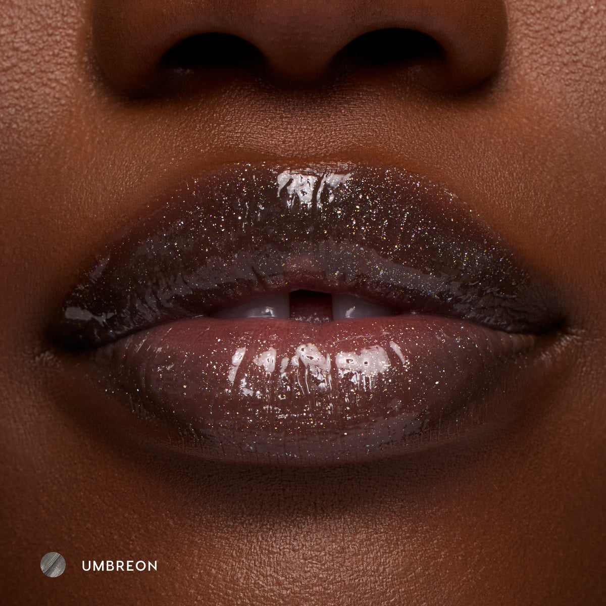 Close-up of deep-tone lips wearing Umbreon sheer black glossy lip balm with high shine