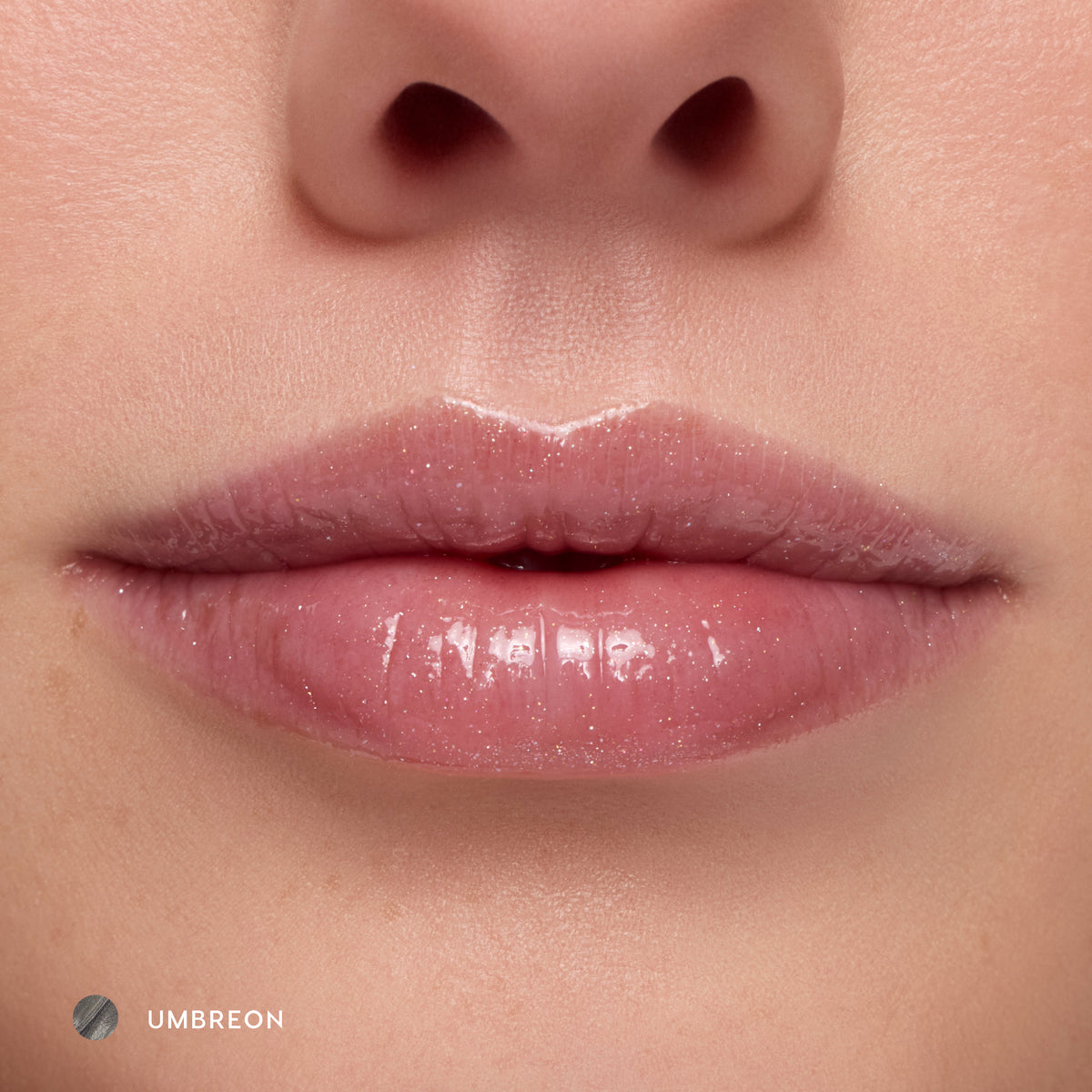 Close-up of fair-tone lips wearing Umbreon sheer black glossy lip balm, which goes on as a sheer gloss