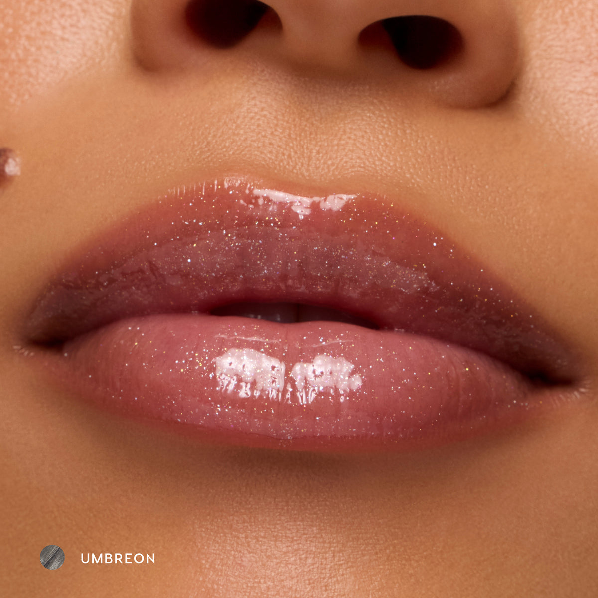 Close-up of medium-tone lips wearing Umbreon sheer black glossy lip balm