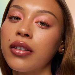 Model with medium skin wearing Flareon tangerine Multichrome Shadow Stix on the lids