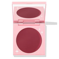 Coyote ColourPop Cream Blush compact sits open, revealing a large pan of deep berry-rose cream in a pink mirrored case with white star accents, photographed on a white background.