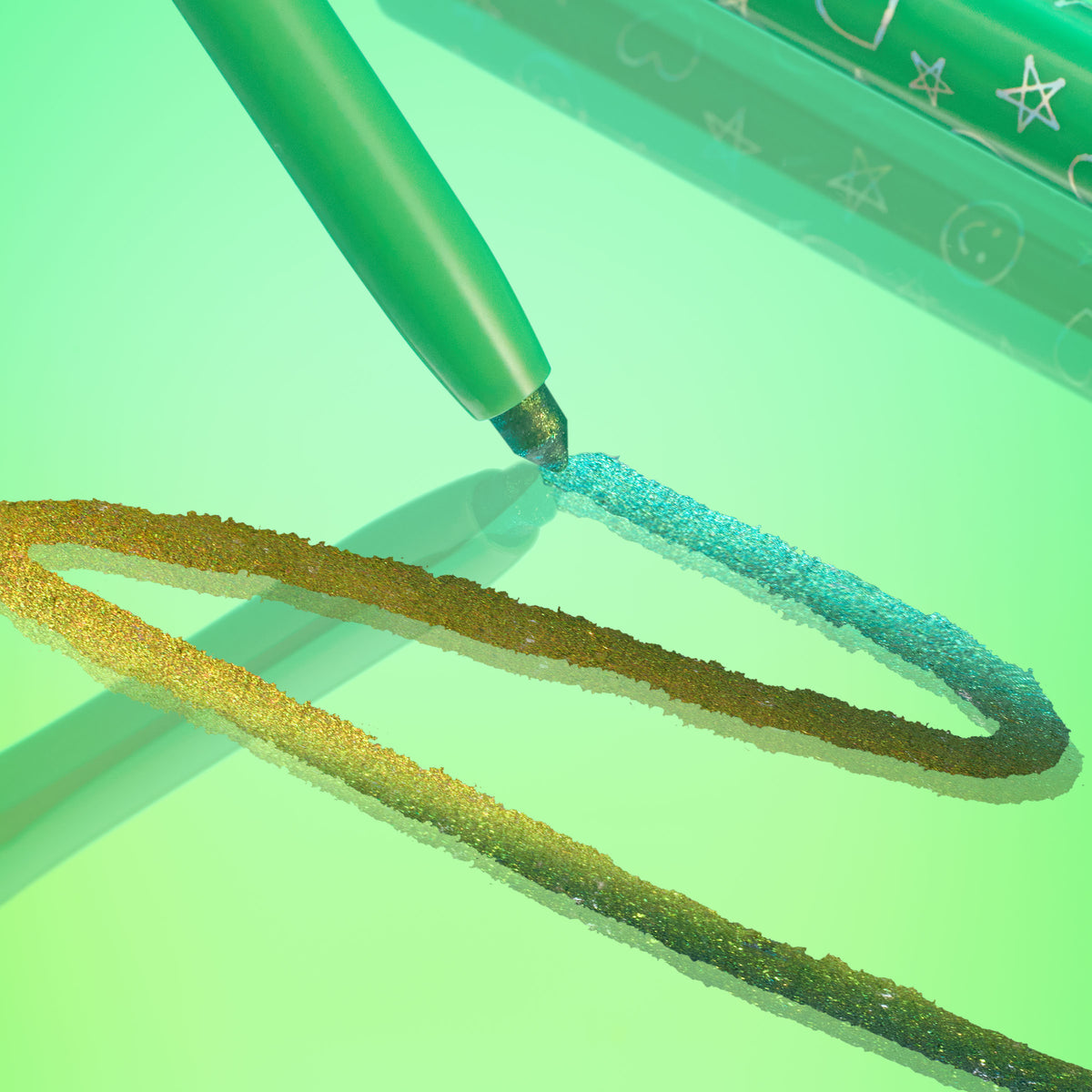 Wild Idea pencil draws a vivid teal-to-gold duochrome line across a glossy green surface, showcasing creamy metallic payoff; ColourPop Chrome Crème Gel Liner with star-and-heart printed barrel shown in a stylized close-up.