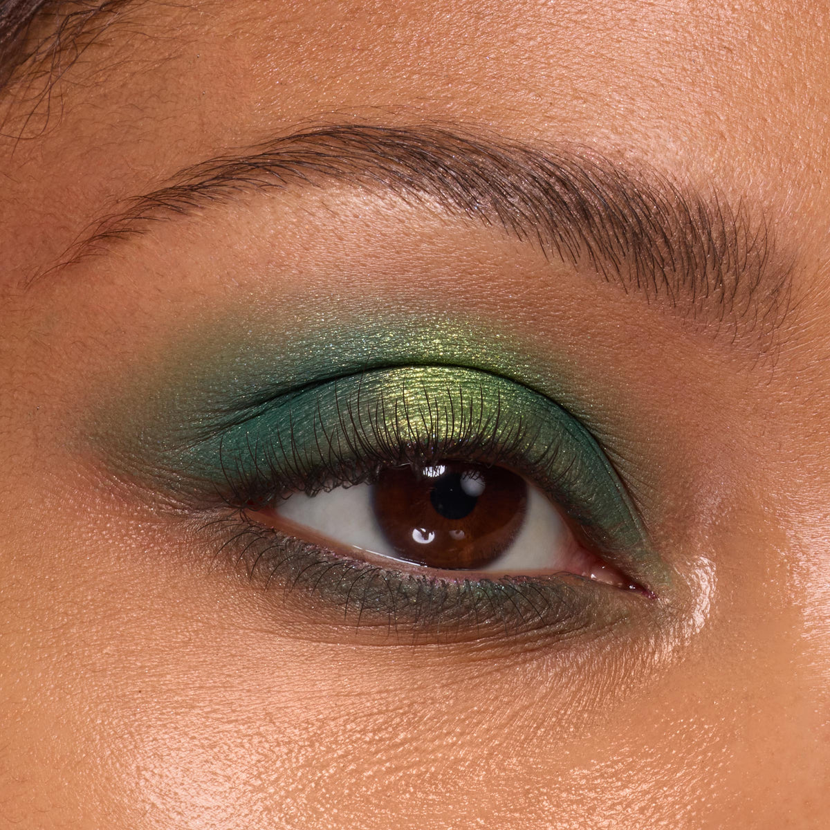 Eyelid showcasing a metallic lime-to-emerald green gradient from the Rainbow Rush Shadow Palette Set, ColourPop green eyeshadow look, with soft mascara and a defined brow in a tight close-up.