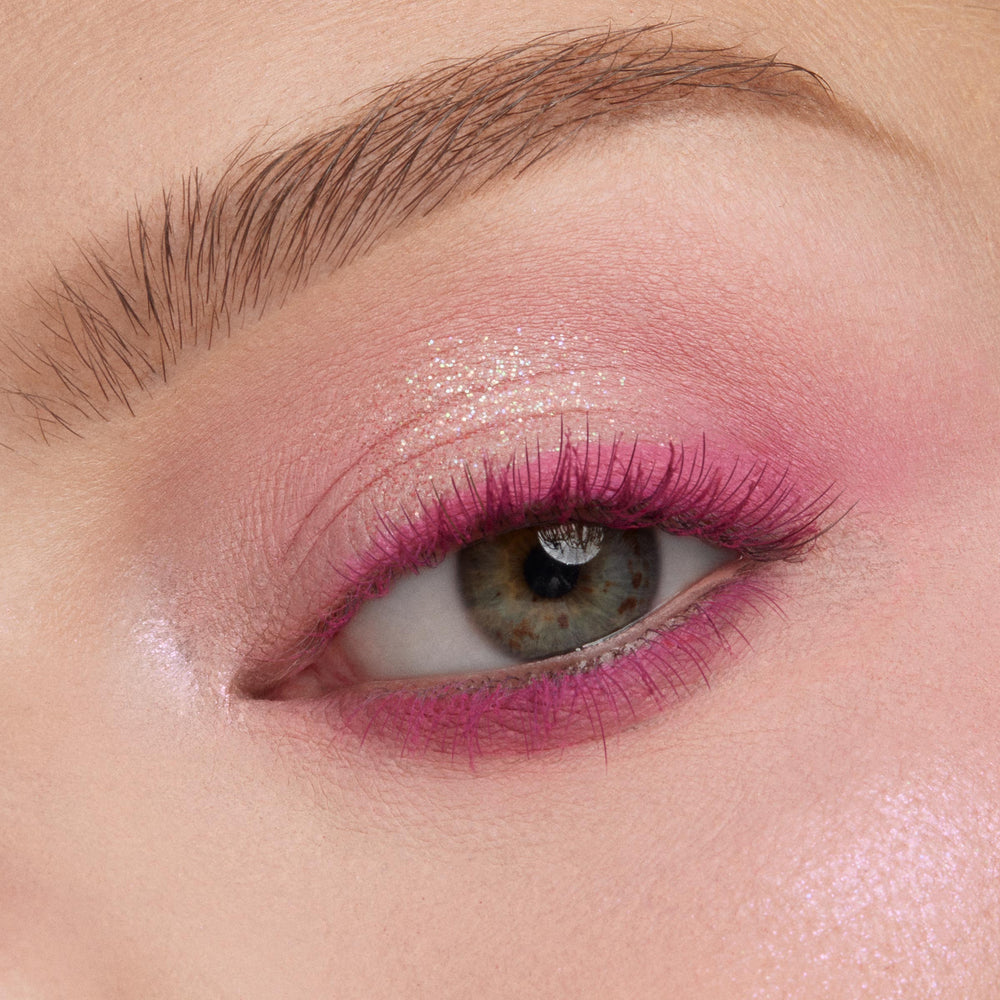 Eyelid with shimmering rose-pink shadow and fuchsia lash line glows in a macro close-up, showcasing blendable shades from the Rainbow Rush ColourPop Shadow Palette Set, a vibrant shadow palette set for bold, sparkly eye looks.