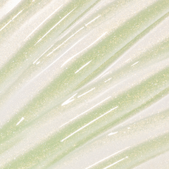 Colourpop Fresh Kiss Glossy Balm in Vanilla Matcha swatched as sheer gold and pale green lip gloss & lip oil with fine gold and silver sparkle streaks across the background, showcasing its shimmery, high-shine finish.