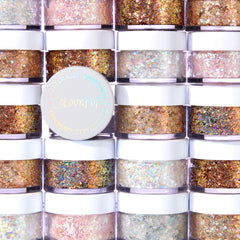Disco Lady glitter gel features chunky iridescent sparkle in a clear base, shown in a round pot with a white, holographic ColourPop lid, set against a wall of stacked ColourPop Glitter Gel jars in assorted shades.