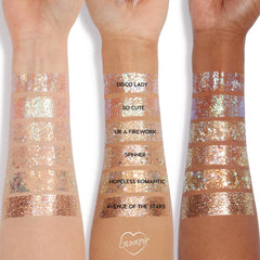 So Cute swatch of ColourPop Glitter Gel shimmering as a sheer peach‑pink iridescent stripe on three arms of different skin tones, shown alongside labeled shades Disco Lady, UR A Firework, Spinner, Hopeless Romantic, and Avenue of the Stars.