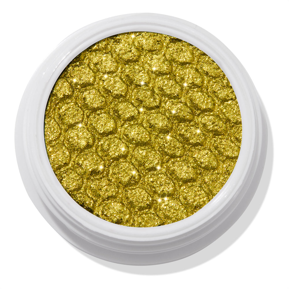 ColourPop Super Shock Shadow Green Juice shimmering in a close-up, the metallic chartreuse green-gold shade sparkles across a dimpled honeycomb texture, housed in an open white round pot on a clean studio background.