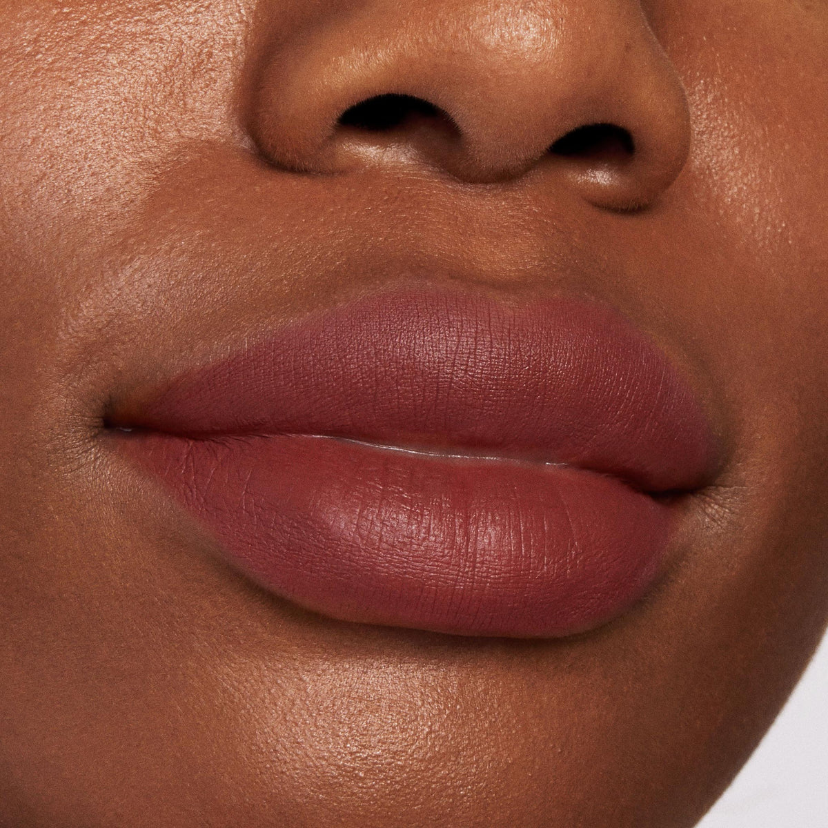 Full lips wearing Grunge, a ColourPop Lippie Pencil lip liner, lining and filling the lips in a matte rose-brown shade; close-up beauty shot highlighting smooth, precise edges and velvety texture.