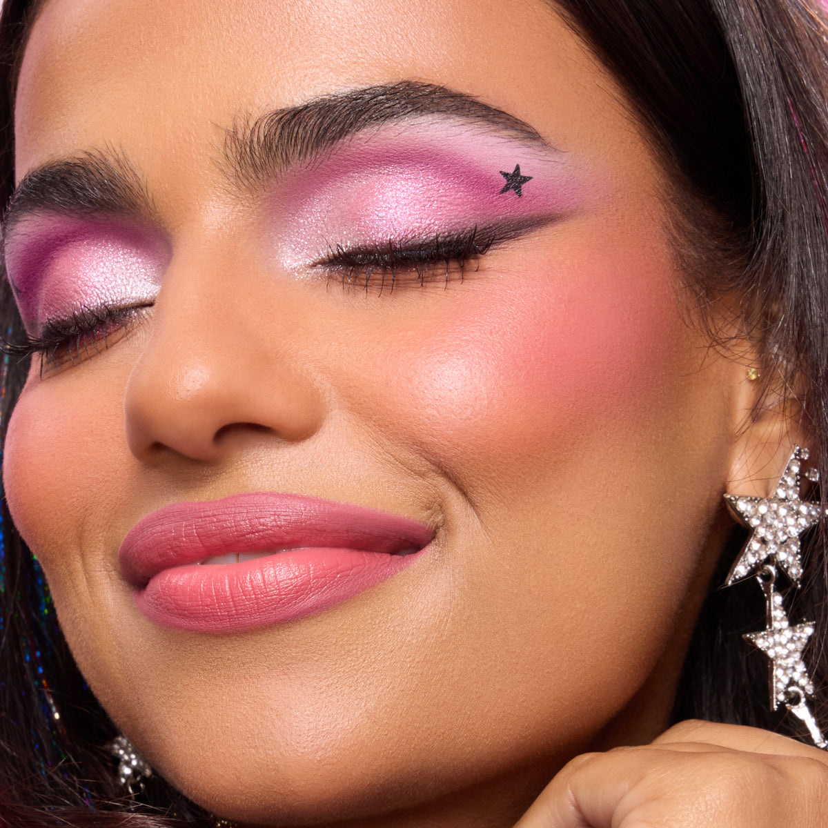 Model with medium skin wearing pink shadow, a black wing and a stamped star from Double Life