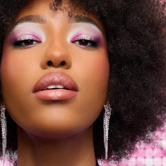 Model with deep skin wearing pink and white shadow and a glossy nude lip from the Best of Both Worlds palette