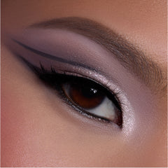 Close-up of a brown eye wearing shimmering mauve and pink shadow from the Heart to Get shadow palette, with sharp graphic black liner and highlighted inner corner, showcasing bold glam eye makeup detail.
