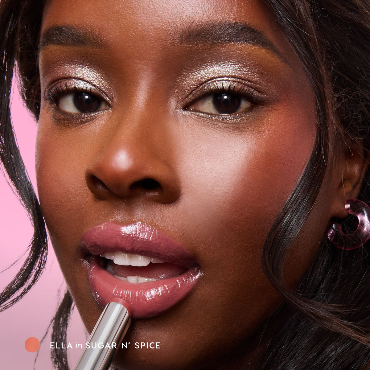 Model with deep skin applying Hyper Shine Glossy Lipstick in Sugar N' Spice