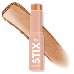 ColourPop Lite Stix in Ignite stands uncapped with the cream highlighter bullet exposed, shown beside a broad swipe of its warm golden shimmer; peach tube labeled “lite STIX” on a clean white background.