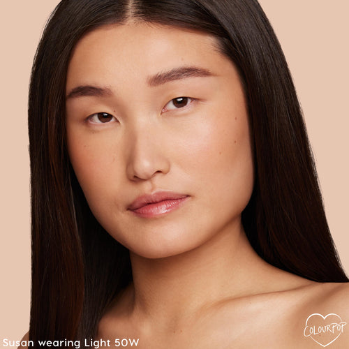 Light 50 W shade of ColourPop Hyaluronic Hydrating Foundation worn on a model, showing medium coverage and a natural dewy finish; close-up face against a soft beige background highlighting warm undertones and smooth, hydrated skin.